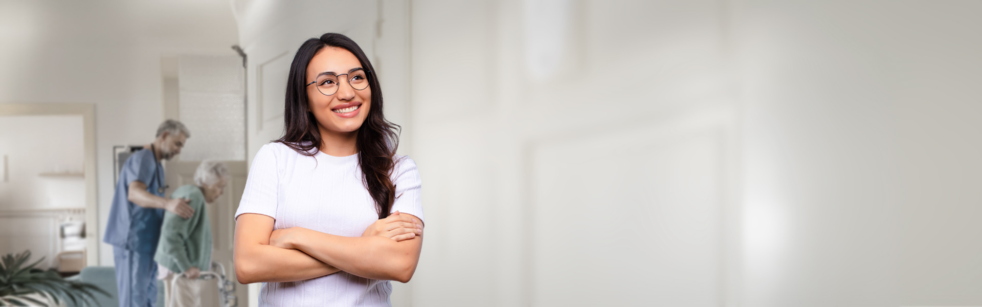 eine lächelnde Frau steht im Flur einer Seniorenresidenz