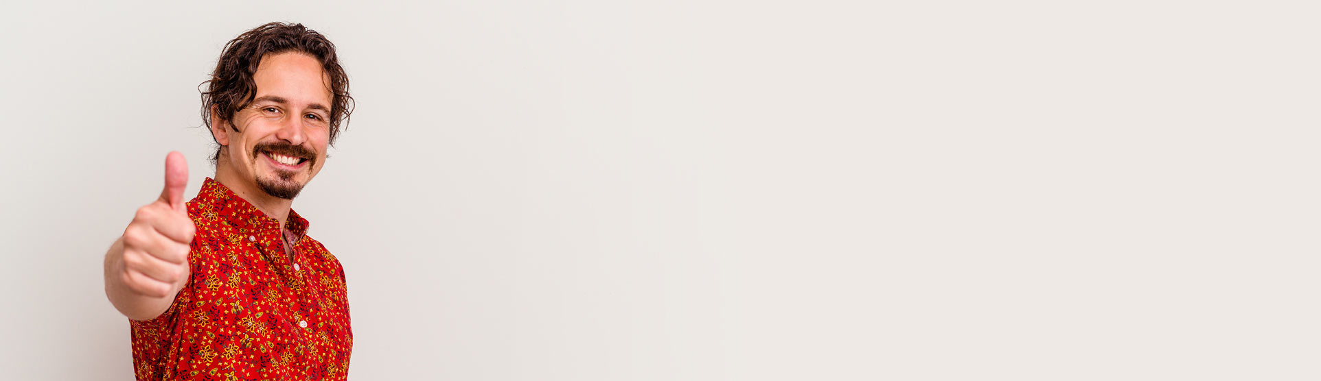 ein Mann in einem roten Hemd, der auf die Kamera zeigt