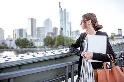 eine Frau steht auf einer Brücke mit einem Laptop