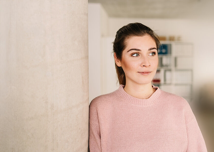 eine Frau, die vor einer Wand steht